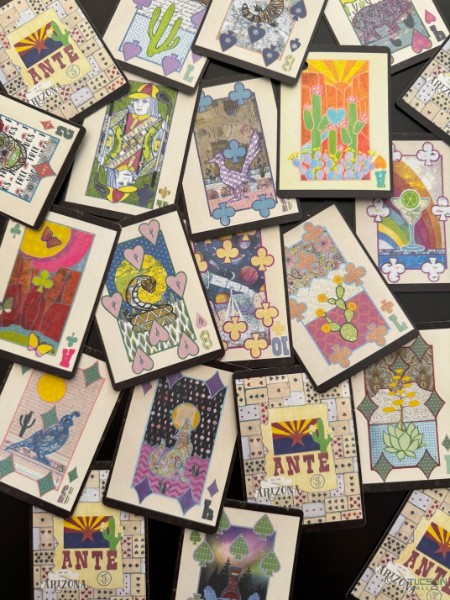 Spread of Arizona ANTE playing cards showing multiple collage faces and patterned backs on a table