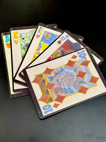 Fan of Arizona ANTE face cards with Ten of Diamonds in foreground on black surface