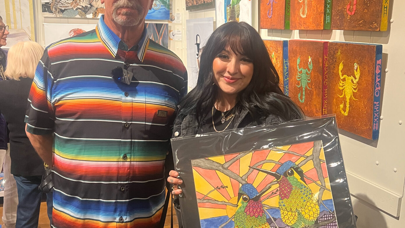 Ralph Philabaum and a happy buyer holding a purchased artwork at the Tucson Gallery event.
