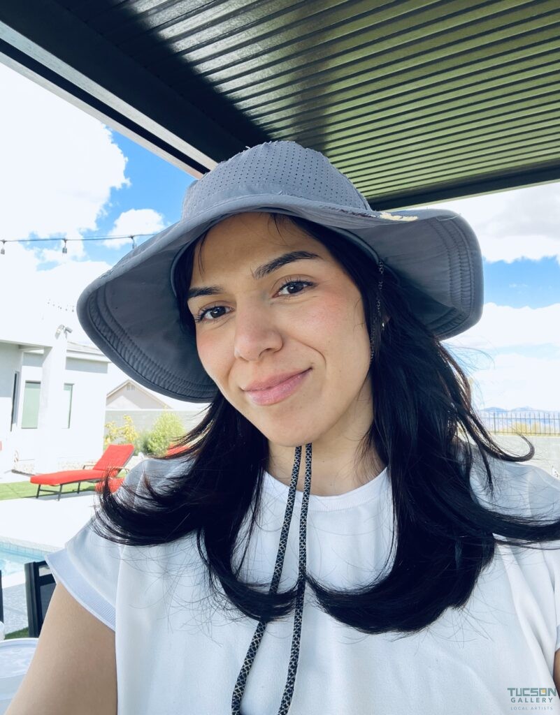 Camila Ibarra smiling in a selfie, with a background hinting at her colorful art studio.