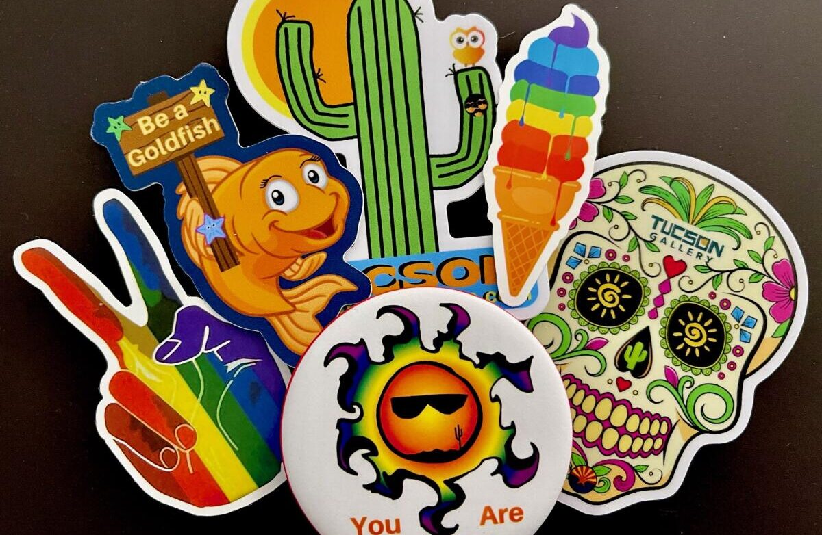 GayTucson "You Are Beautiful" magnetic button and five colorful Pride stickers including a peace sign in rainbow colors, Be a Goldfish sticker, Tucson Gallery cactus sticker, melting ice cream in rainbow colors, and Tucson Gallery sugar skull sticker.