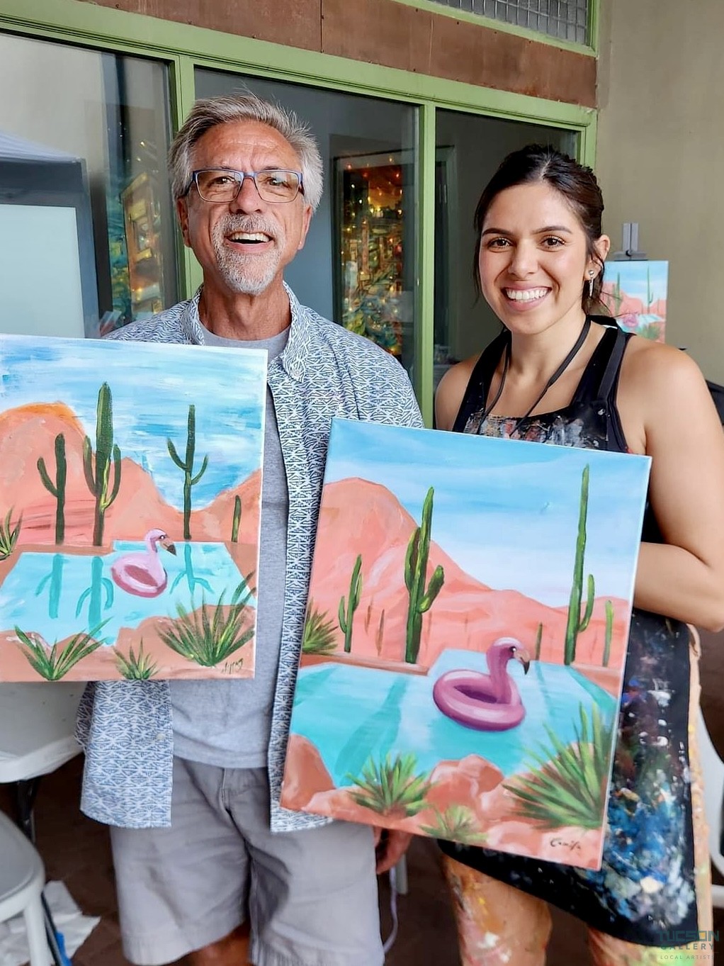 Camila Ibarra posing with a student and their artwork after a Paint and Sip class