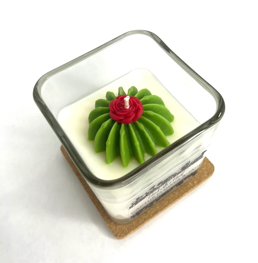 Top view of soy barrel cactus candle with red flower detail, a Tucson Gallery souvenir and gift.