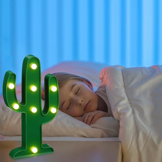 Young girl sleeping peacefully with the desert-themed night light as her night companion, available at Tucson Gallery.