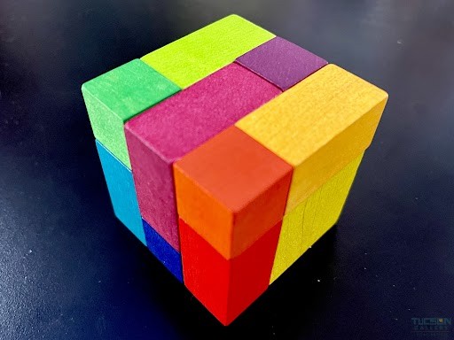 Playable ART Cube rainbow wooden puzzle cube on a dark tabletop at Tucson Gallery