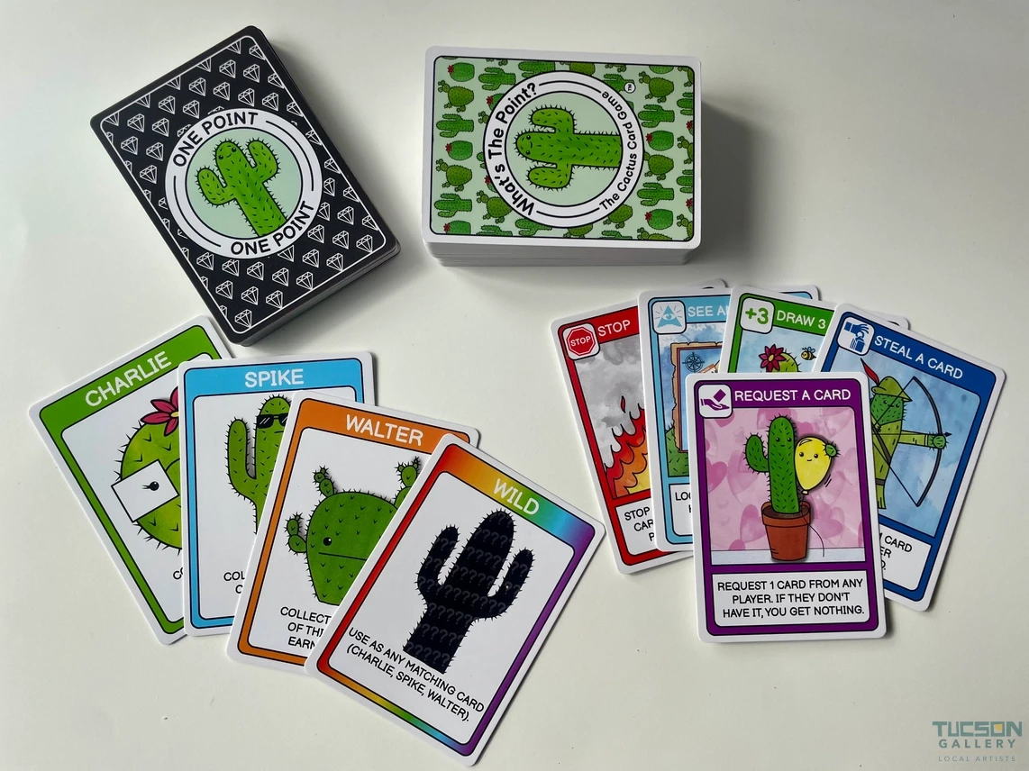Cactus-themed card game cards laid out on a table with character cards and action cards, a fun Tucson souvenir gift.